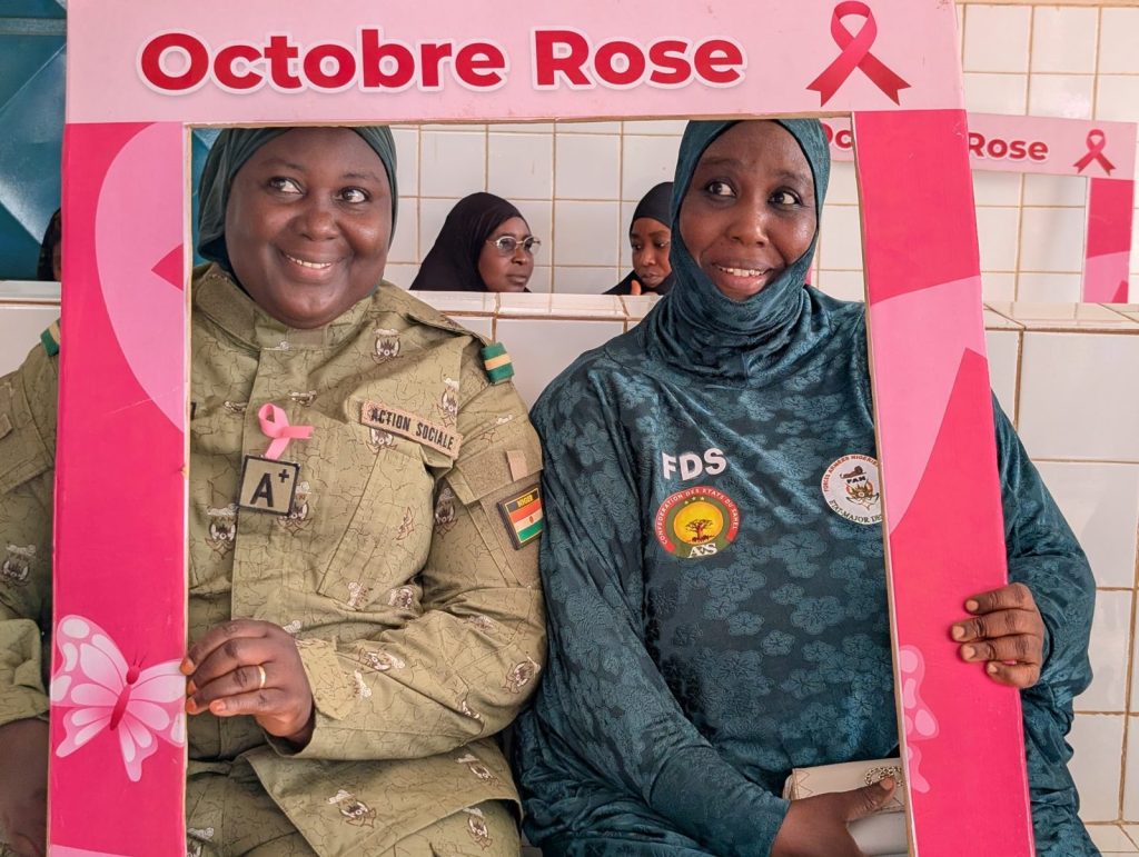 Deux femmes des FDS souriantes dans le cadre photo Octobre Rose de la Clinique Afoua