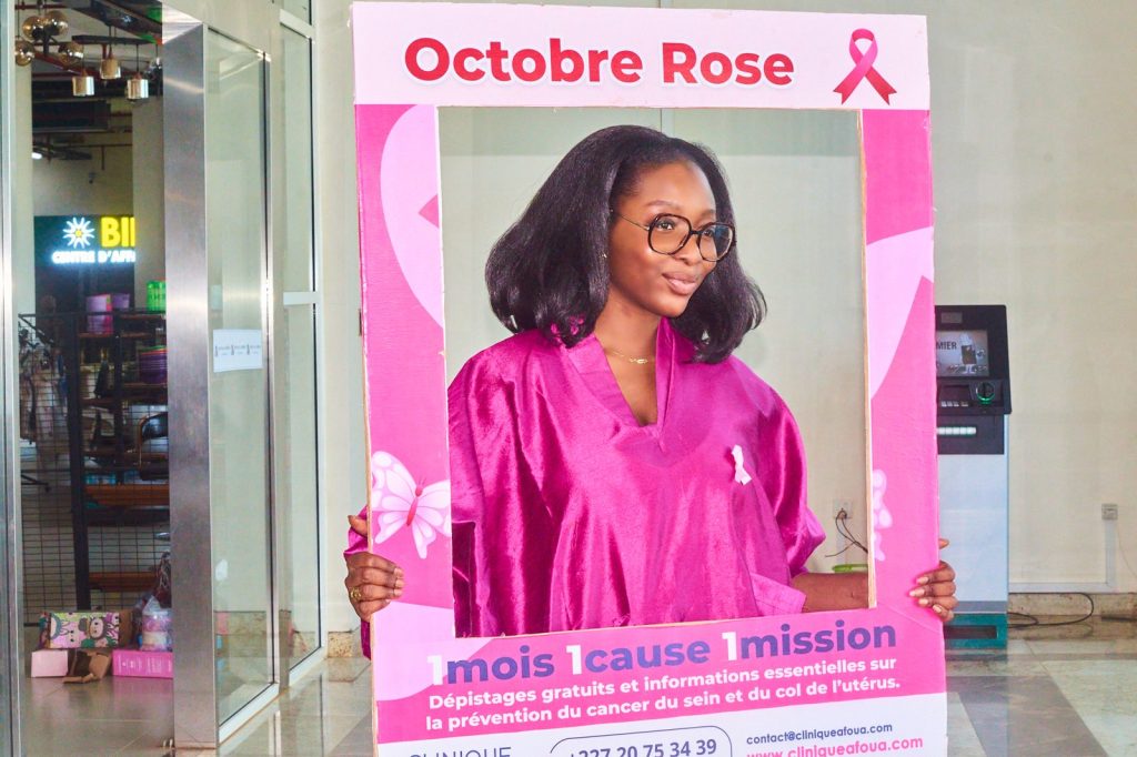 Visiteuse en rose posant dans le cadre photo Octobre Rose dans la galerie de Niamey Mall