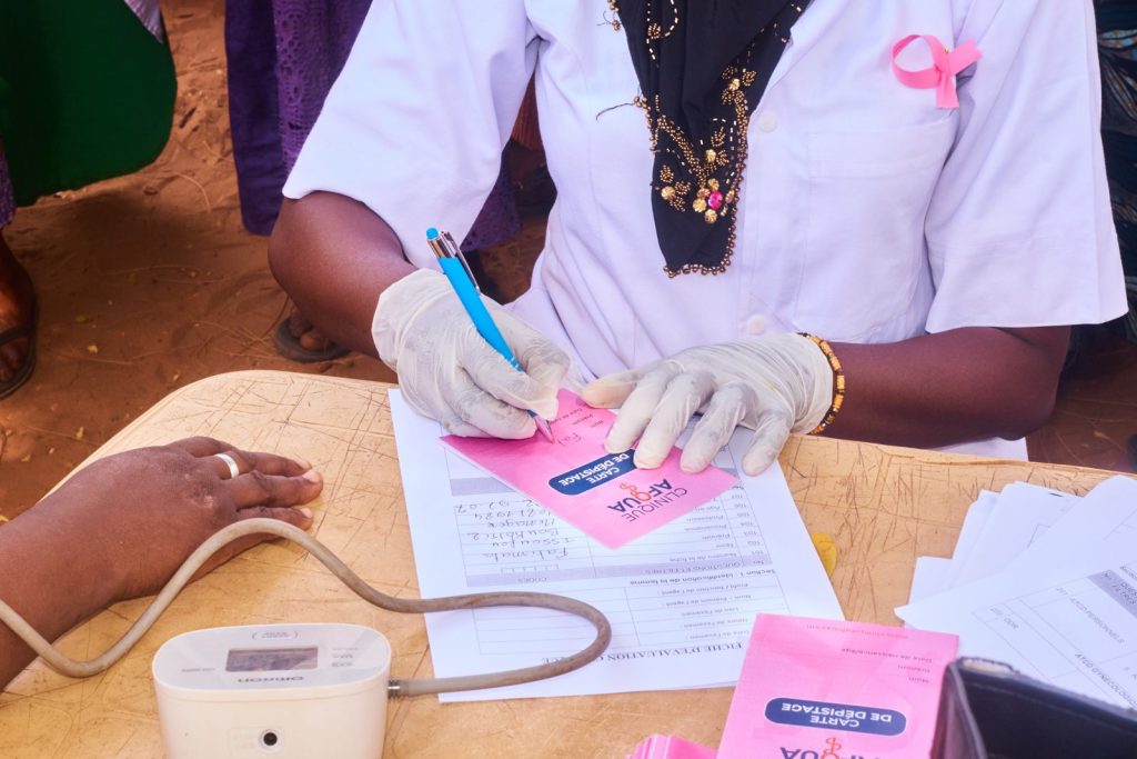 Soignante de la Clinique Afoua remplissant une carte de dépistage Octobre Rose