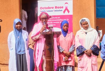 Dépistage à Koira Tegui : prise de parole devant le kakemono Octobre Rose de la Clinique Afoua au CSI