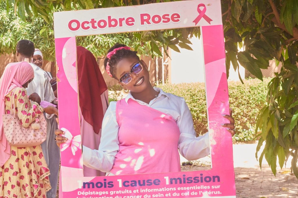 Étudiante de l’ESCAE souriante dans le cadre photo Octobre Rose