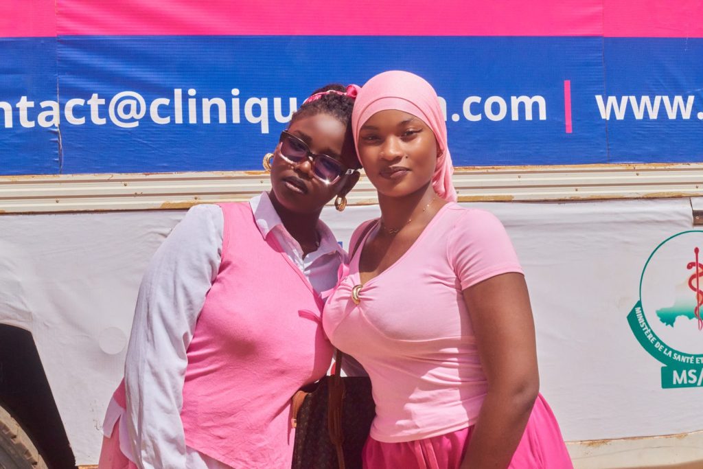 Deux étudiantes en rose devant la clinique mobile Afoua