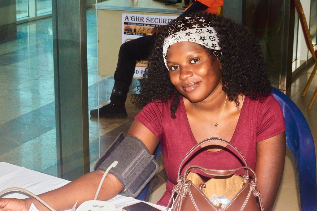 Visiteuse souriante pendant la prise de tension au stand Octobre Rose de Niamey Mall