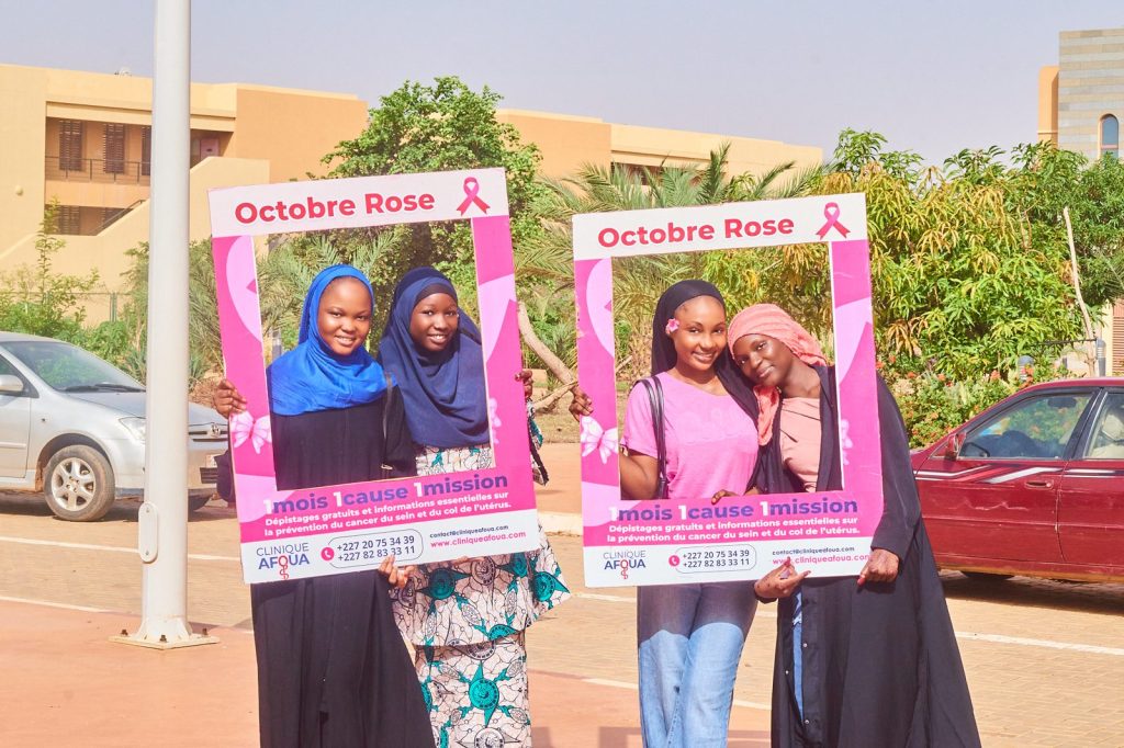 Quatre étudiantes souriantes avec les cadres Octobre Rose devant l’Université Islamique
